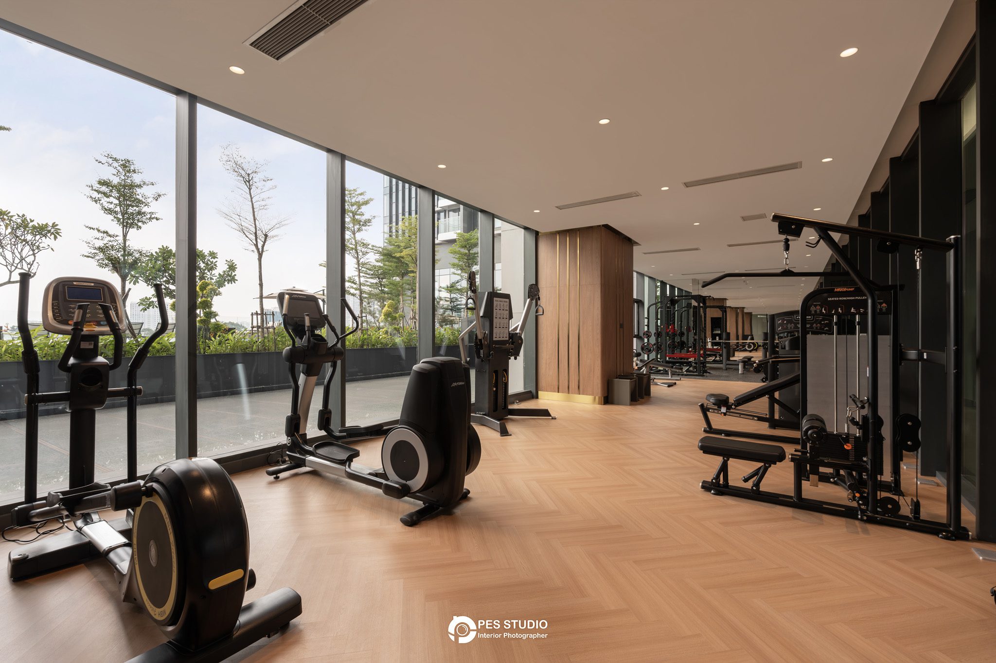 Phòng gym Lancaster Legacy nhìn dọc dãy máy tập bên cửa kính
