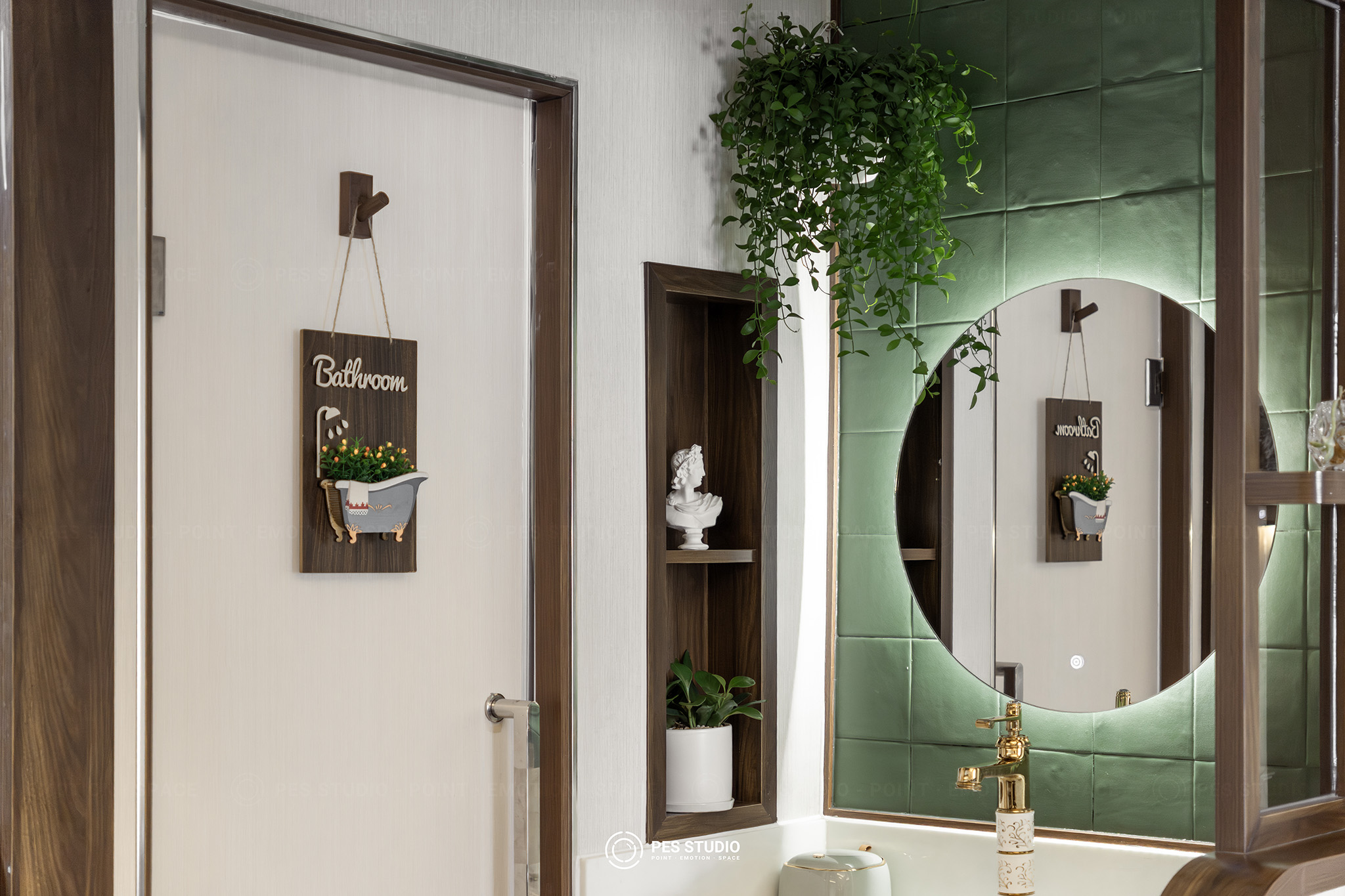 Cửa phòng trị liệu Yvan Aesthetics với gương tròn và mảng cây xanh