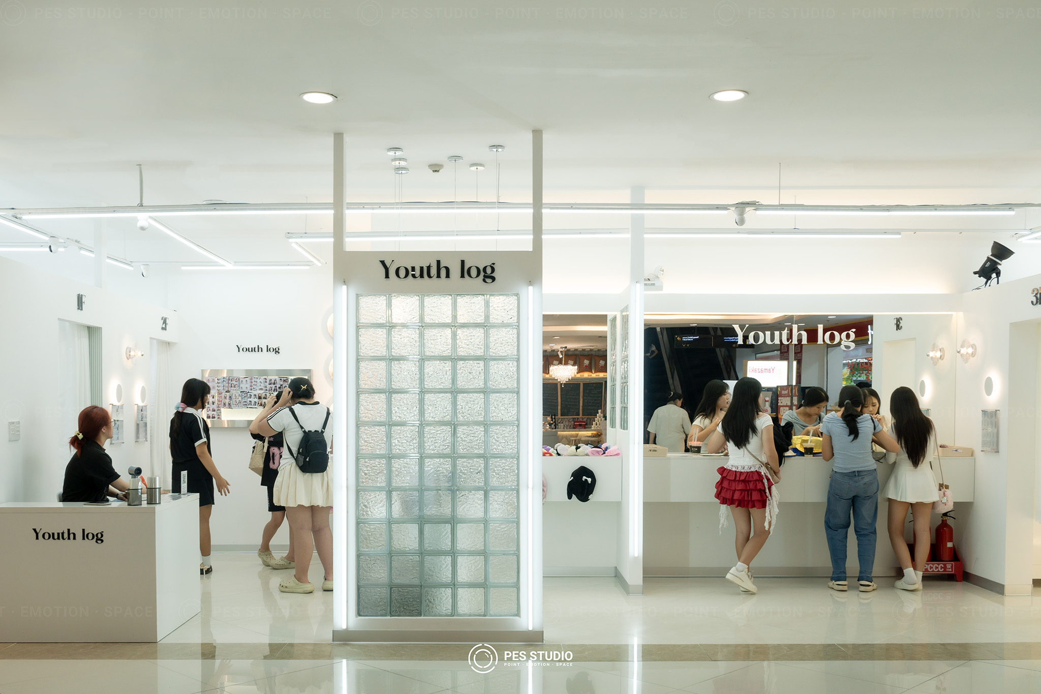Kính râm nhiều kiểu bày trong khay ô vuông dưới bảng hiệu Youth Log