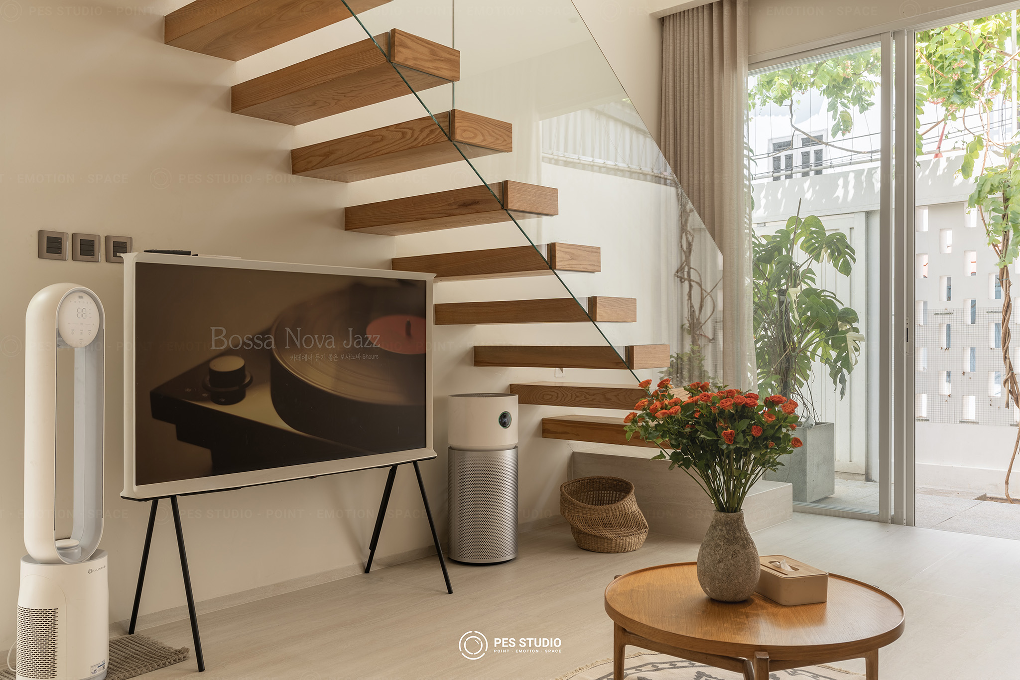 Cầu thang bậc gỗ không tay vịn nhìn từ phòng khách nhà phố