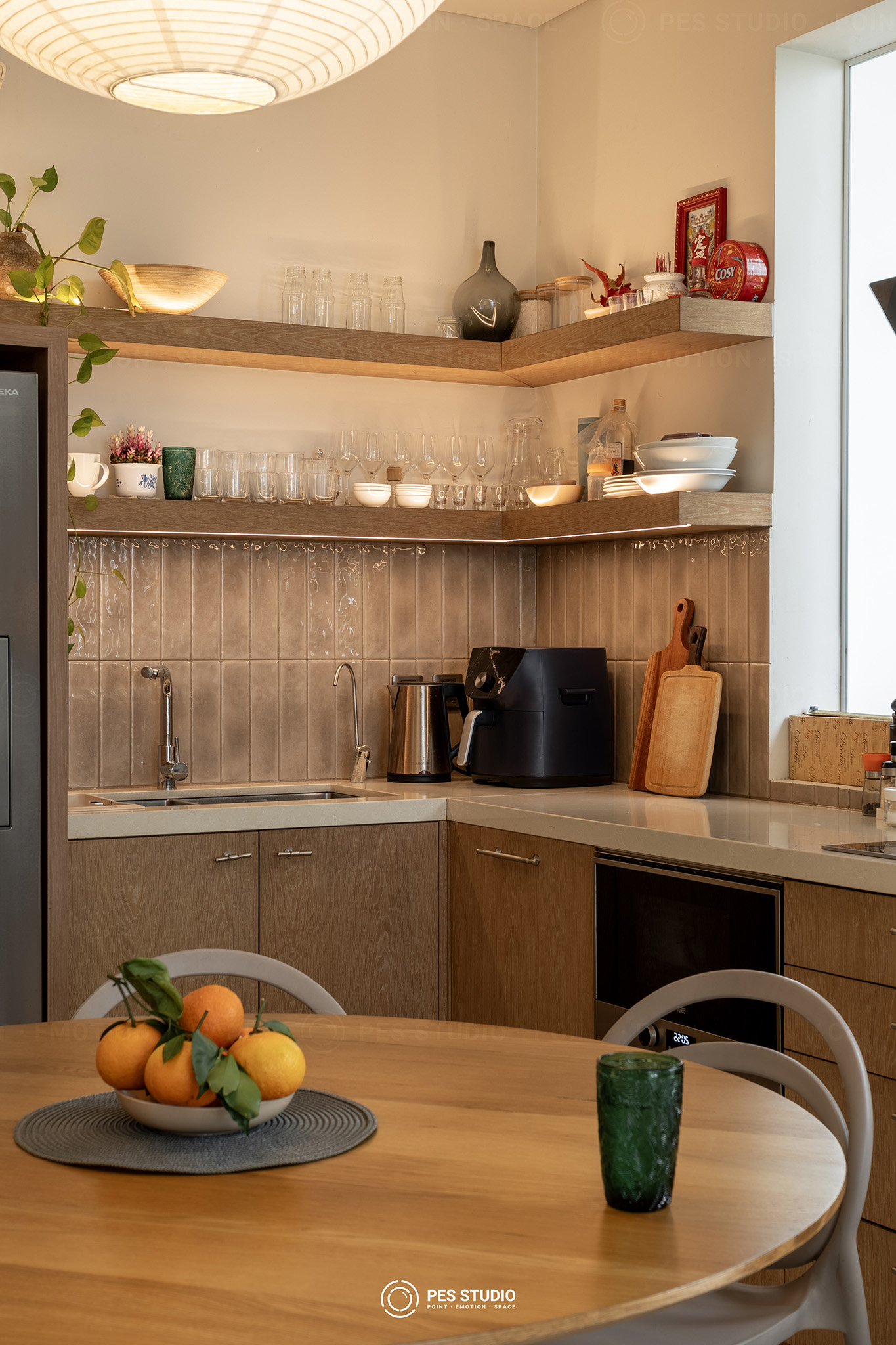 Bếp chữ L ốp gỗ sáng với kệ mở và bộ ghế Thonet trắng