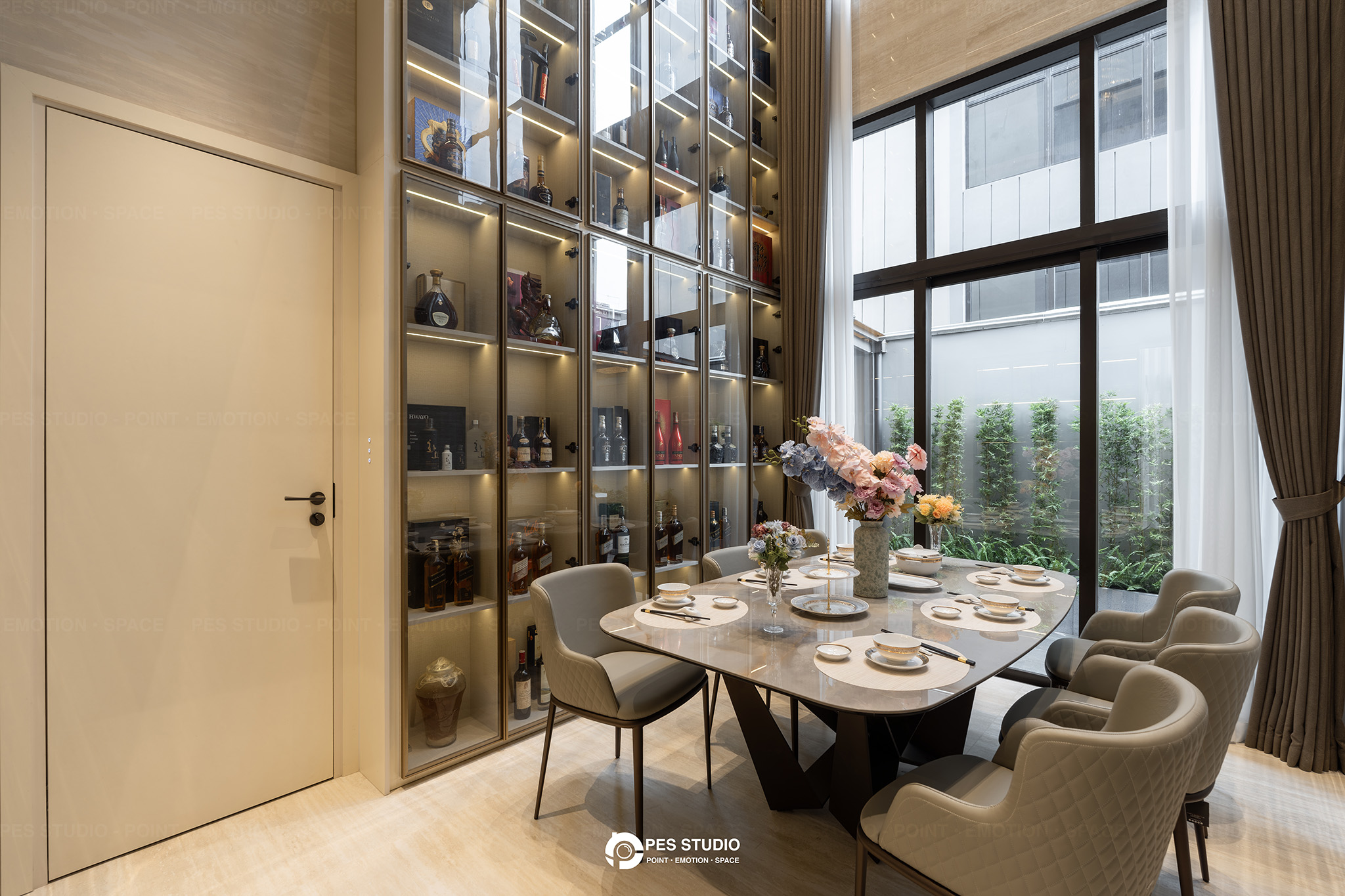 Phòng ăn villa Sycamore với tủ kính cao kịch trần và bàn ăn mặt đá