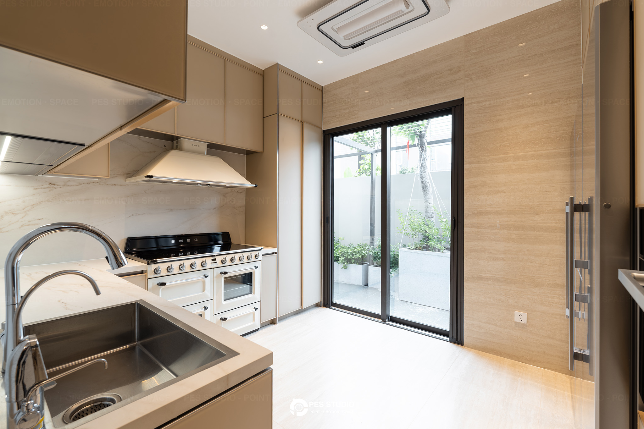 Khu bếp villa Sycamore với cửa kính ra sân và chậu rửa inox