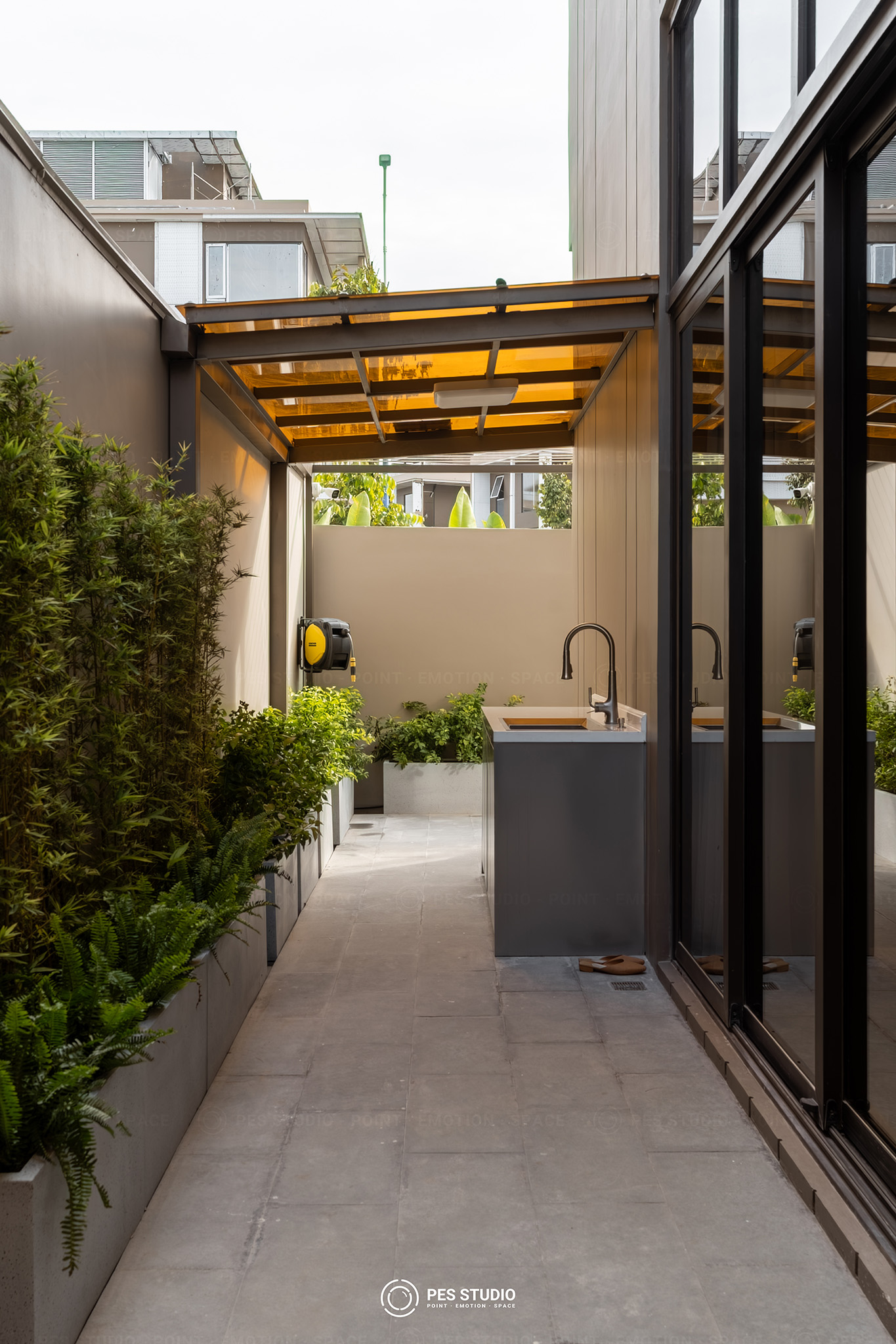 Hành lang ngoài trời villa Sycamore với quầy bếp và cây leo hai bên