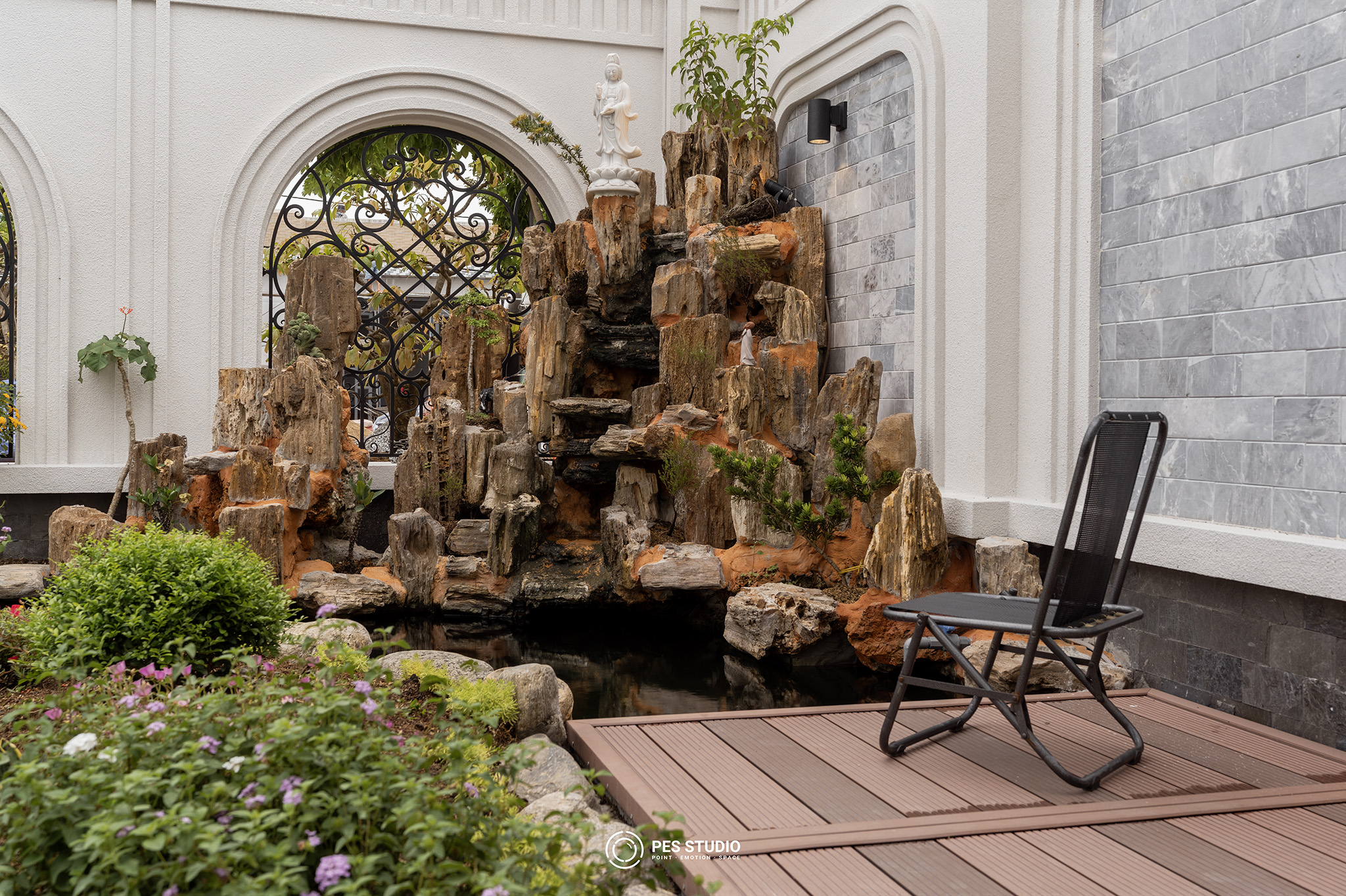 Mặt tiền villa tân cổ điển nhìn từ vỉa hè, hàng bonsai trước tường rào