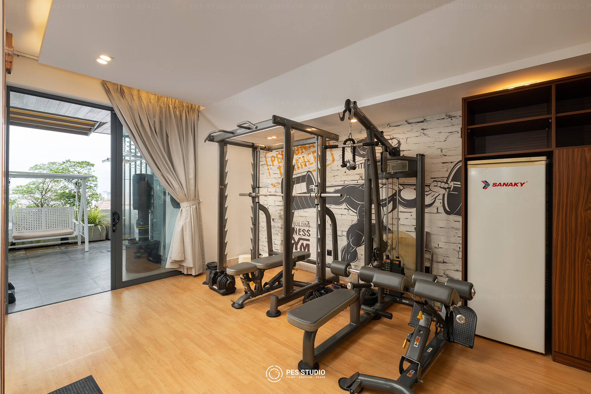 Phòng gym riêng trong villa Trần Xuân Soạn với giàn tạ và sàn gỗ sáng
