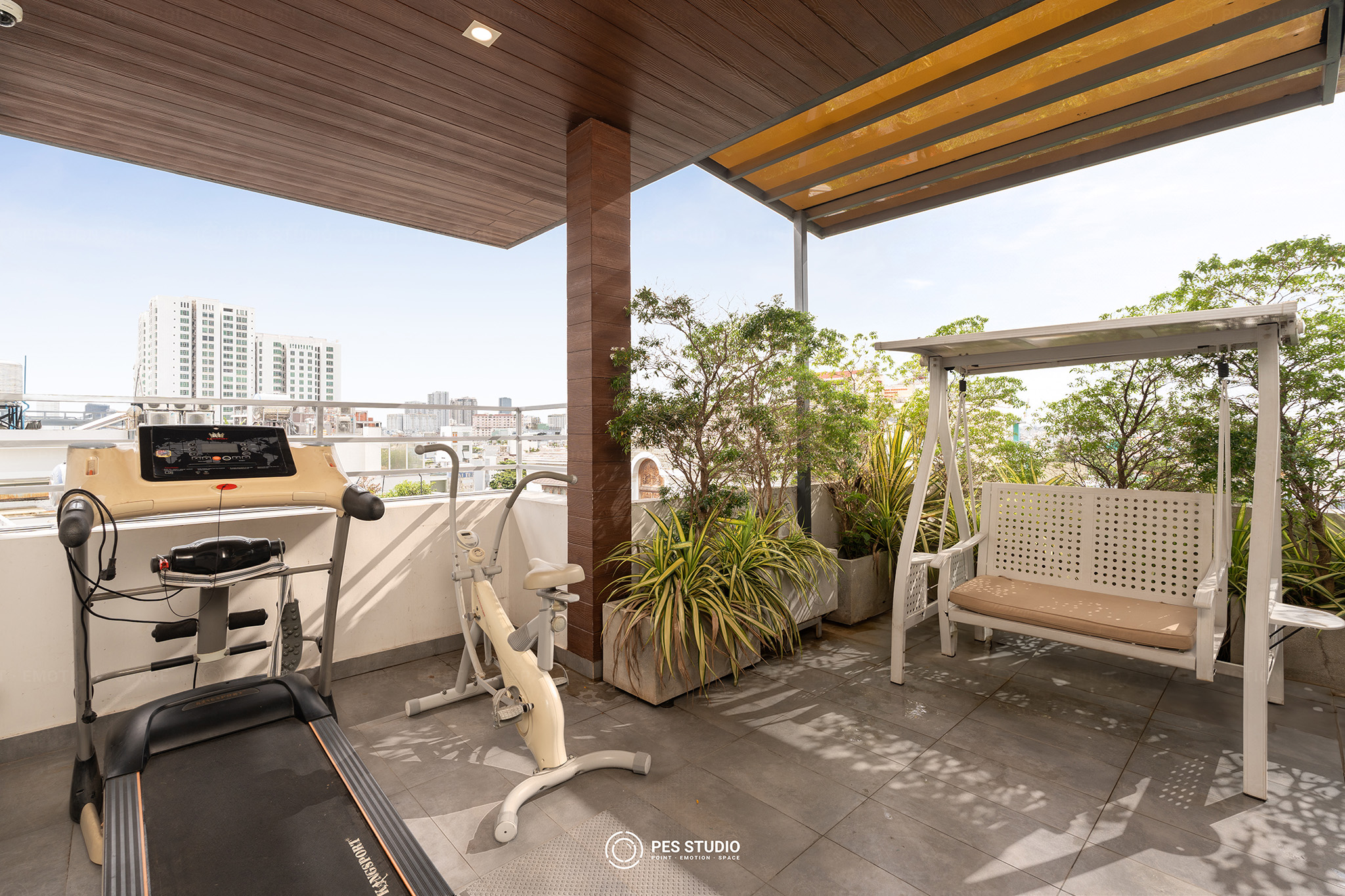Sân thượng villa quận 7 với xích đu gỗ, giàn pergola và cây xanh