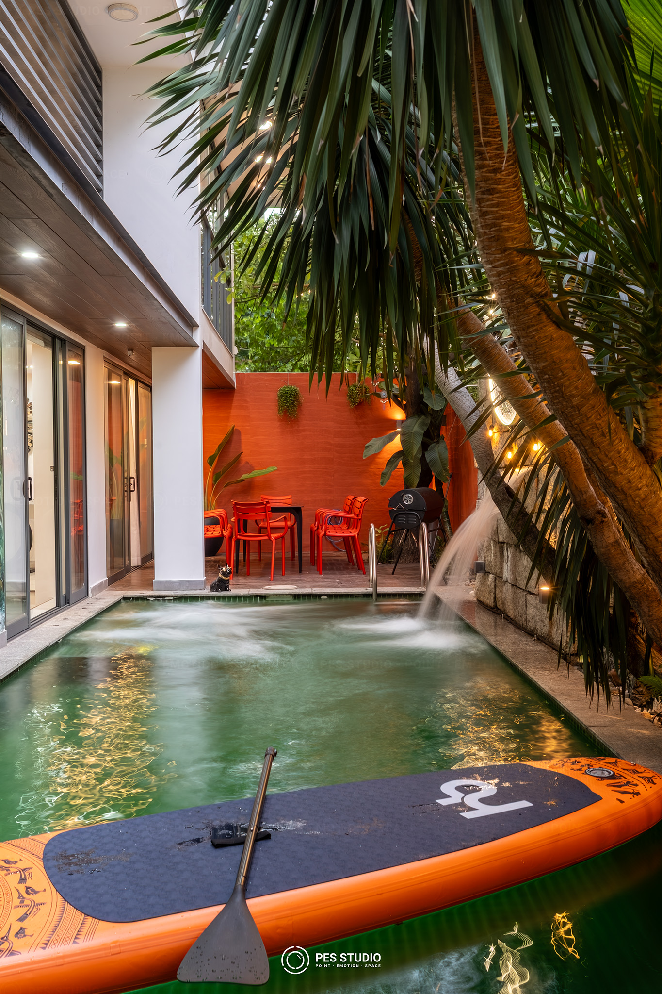Hồ bơi trong nhà villa quận 7 với ván SUP và giếng trời phủ cây