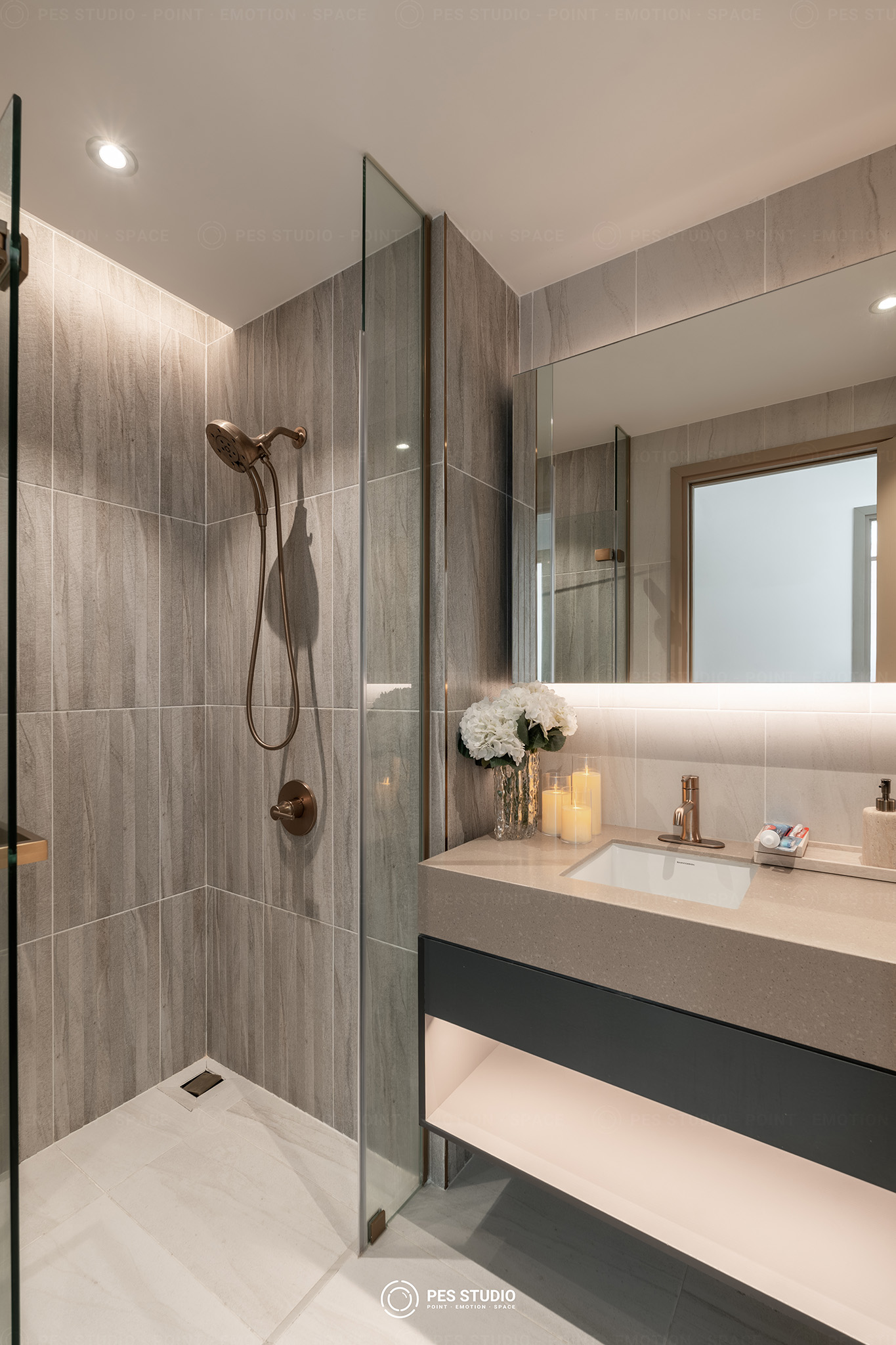 Phòng tắm căn hộ Antonia với buồng sen kính, lavabo đá và vòi mạ đồng