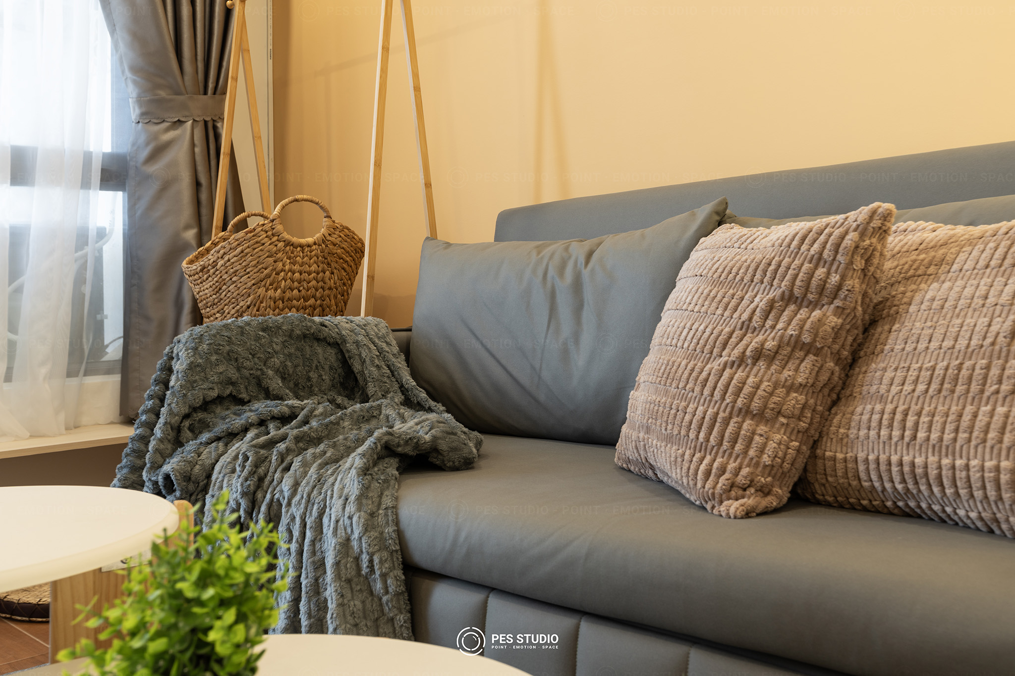 Cận cảnh sofa xám với gối tựa và chăn dệt trong căn hộ cho thuê Vũng Tàu