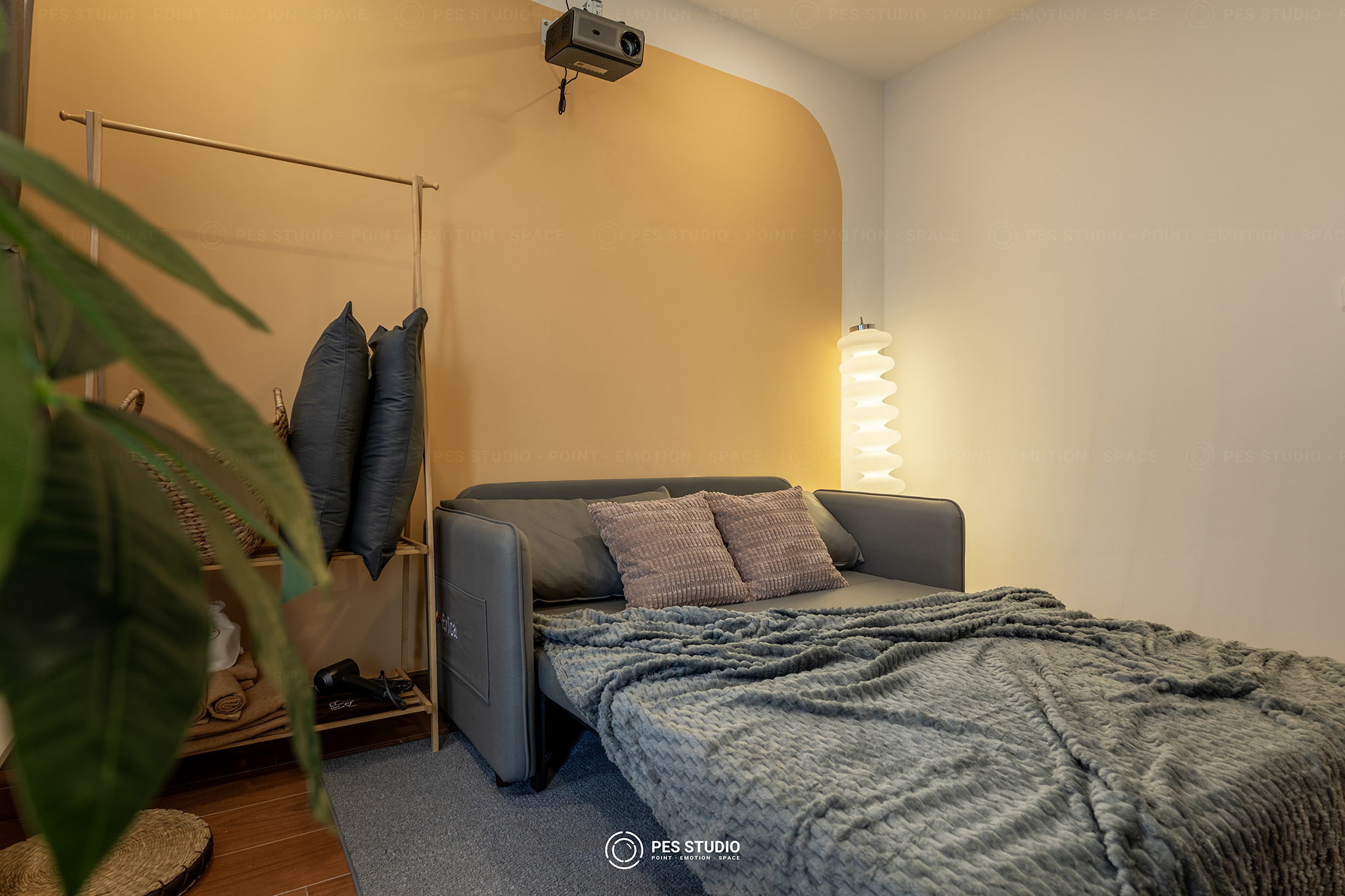 Phòng ngủ thứ hai căn hộ Duotori với sofa giường và tường cong bo tròn