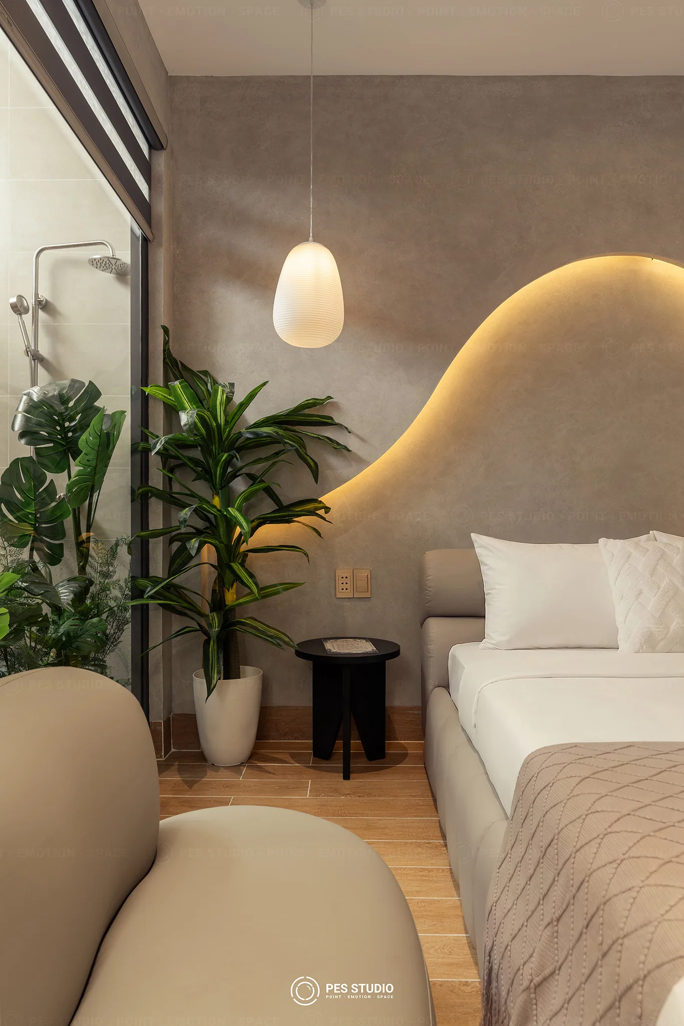 Chi tiết mảng tường lượn hắt sáng và cây xanh trong giếng trời tại Cô Hai Homestay Mỹ Tho