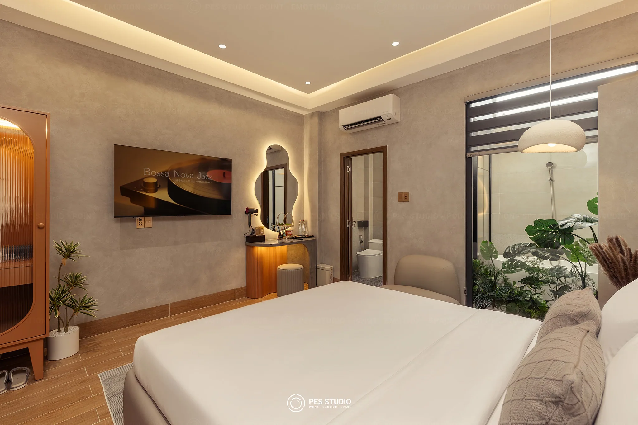 Phòng ngủ Cô Hai Homestay Mỹ Tho với vách kính nhìn sang phòng tắm và giếng trời trồng cây