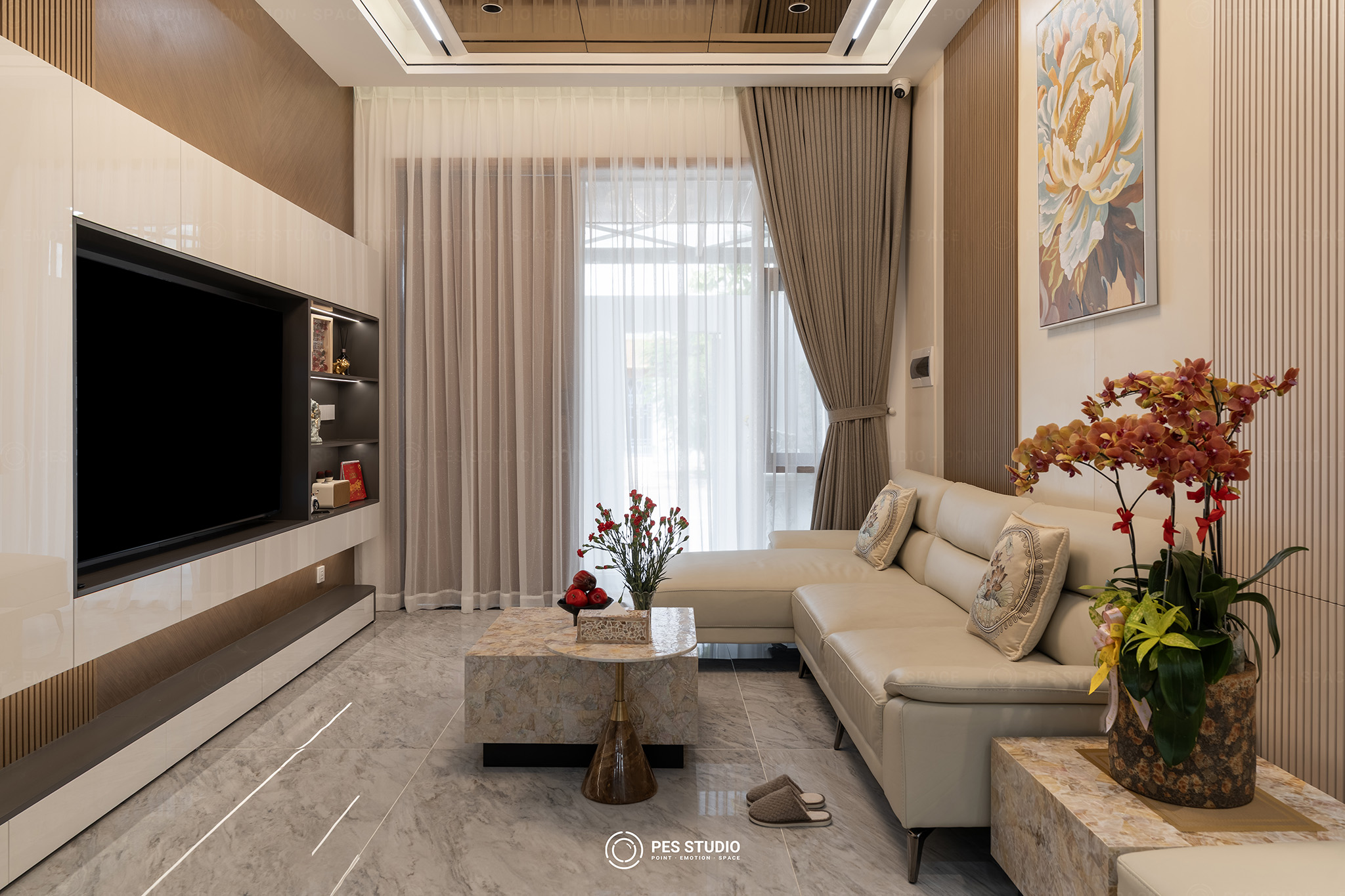 Chụp ảnh nội thất Long An: quy trình, chi phí và kinh nghiệm thực tế 1 Chụp ảnh nội thất Long An — phòng khách nhà phố với sofa tông kem, tường TV ốp gỗ và rèm cửa sổ lấy sáng