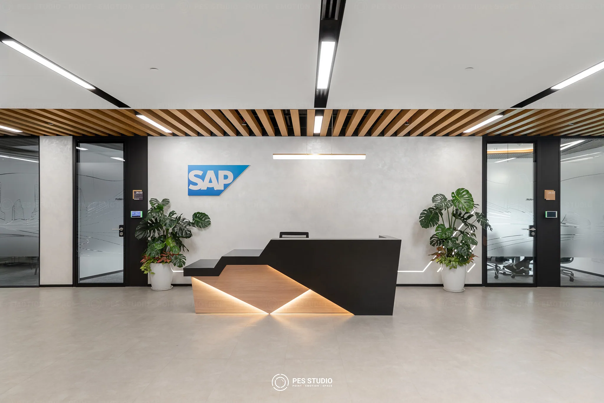 Chụp ảnh văn phòng SAP toà Nexus — quầy lễ tân dưới logo SAP và trần lam gỗ, PES Studio