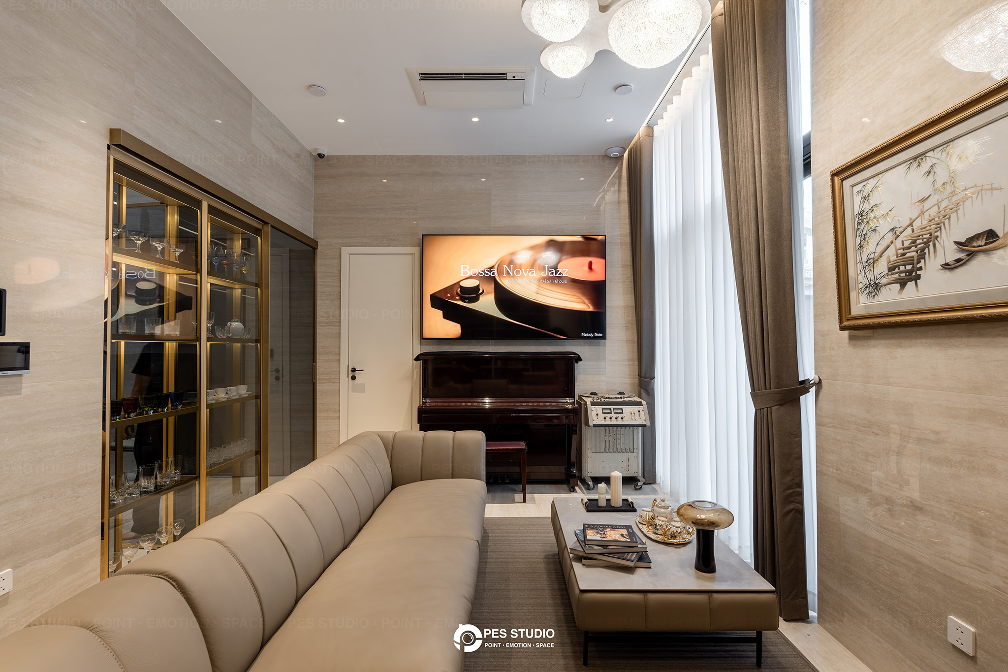 Ảnh nội thất phòng khách biệt thự nhà vườn do PES Studio thực hiện, sofa da kem, tủ rượu kính khung đồng và đàn piano