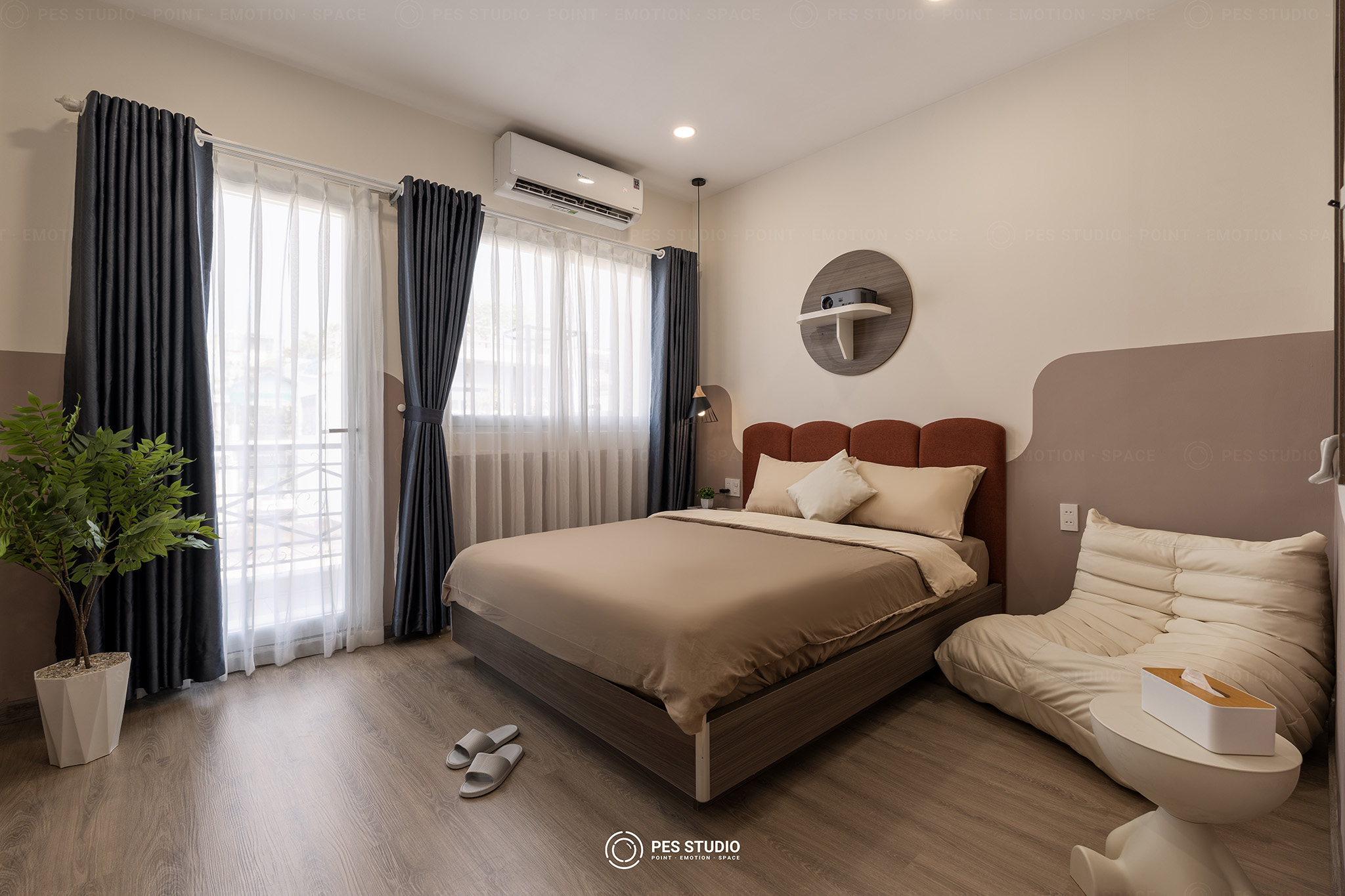 Ảnh nội thất phòng ngủ homestay do PES Studio thực hiện, đầu giường bọc nỉ đỏ gạch, ghế Togo kem và rèm hai lớp đón sáng